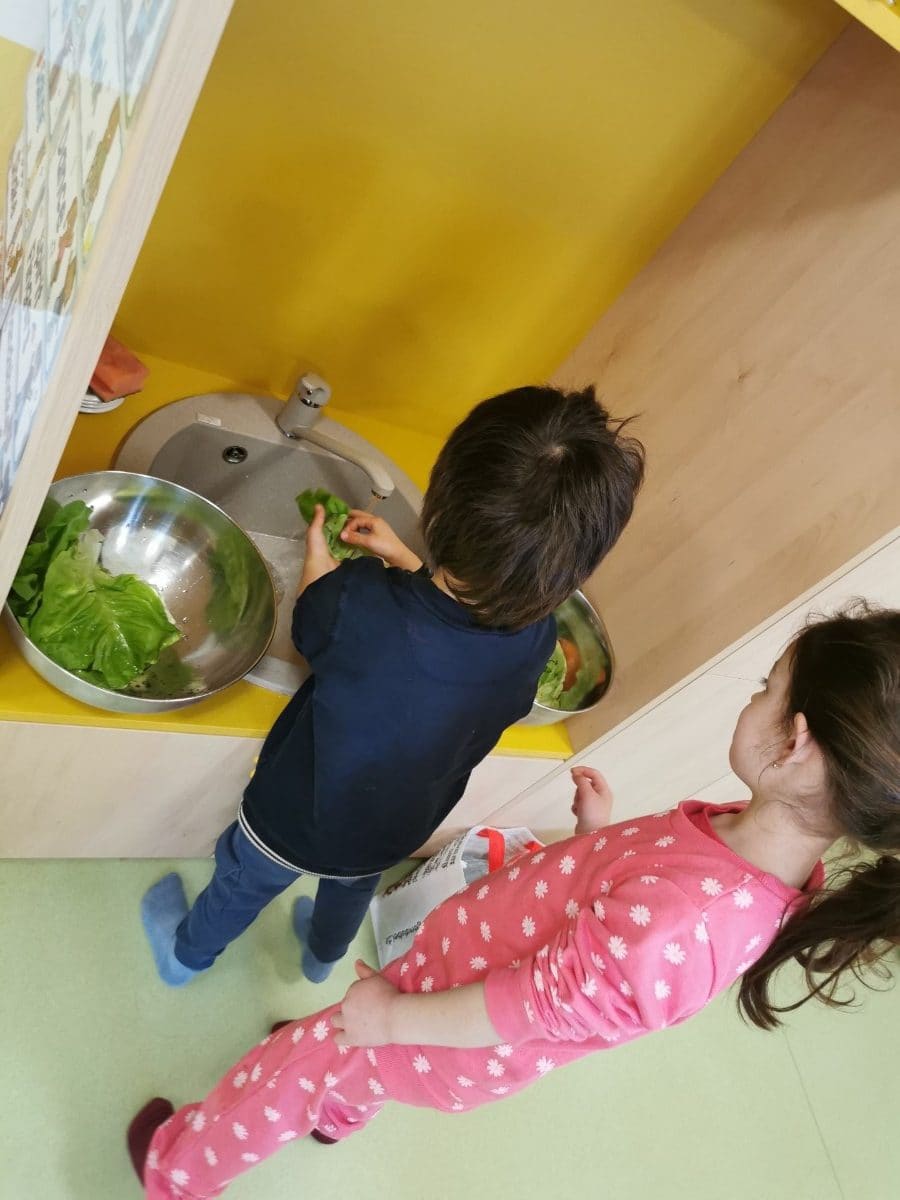 Kinder waschen Gemüse am kindgerechten Waschbecken
