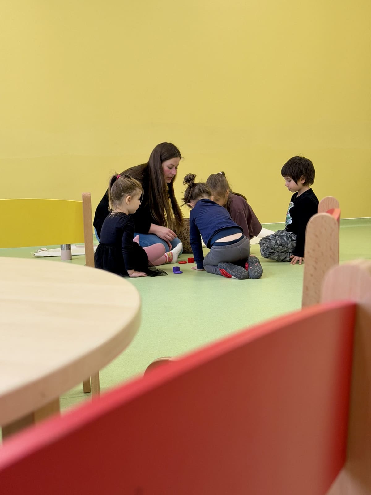 Erzieherin spielt mit den Kindern im Gruppenraum