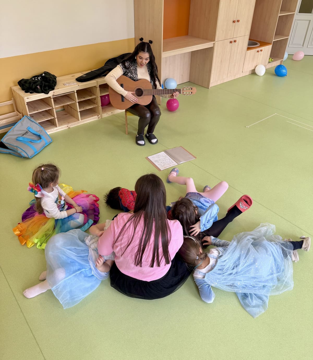 Erzieherin spielt Gitarre für die Kinder