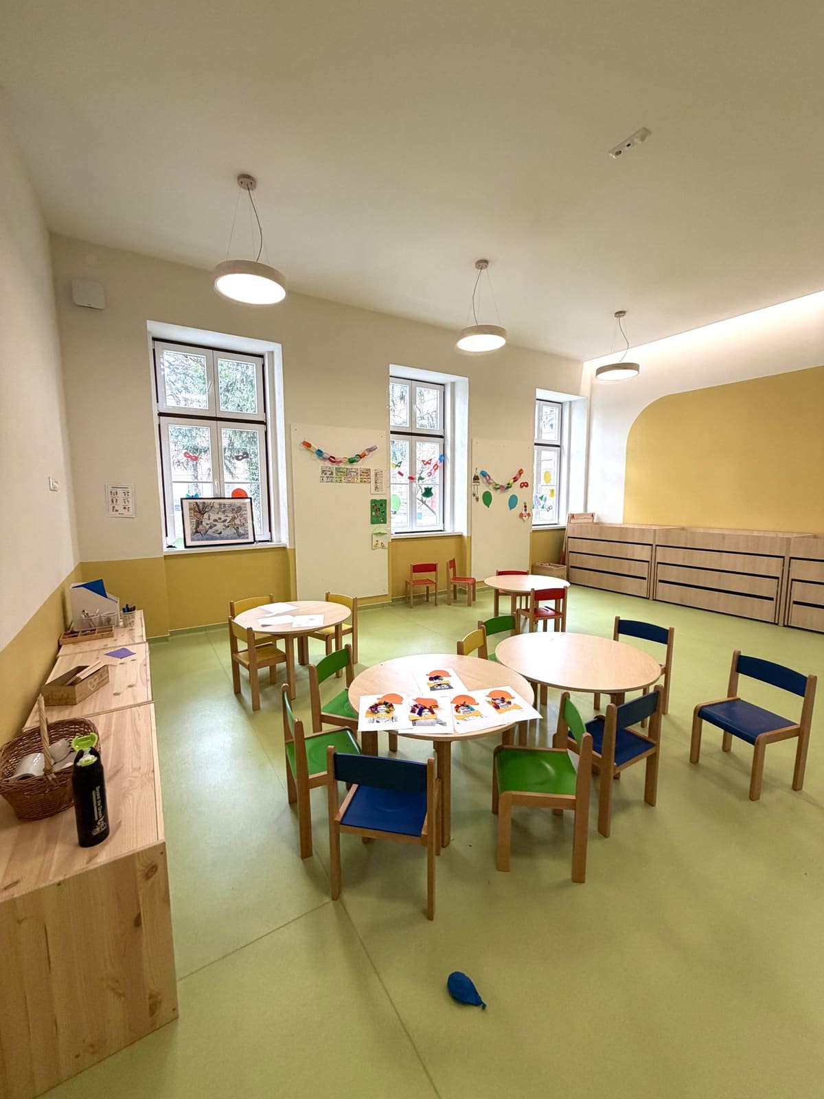 Runde Tische und bunte Stühle im Gruppenraum